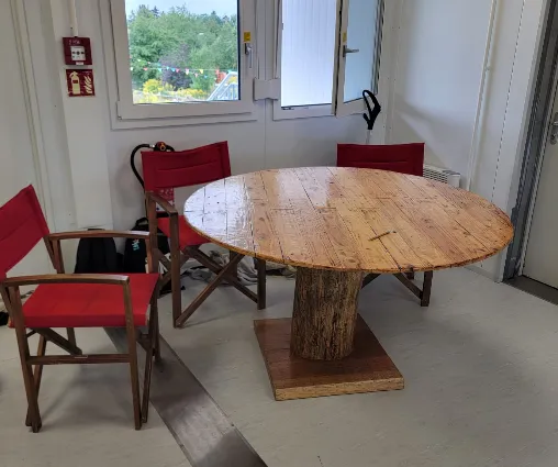 Ein runder Holztisch mit roten Stühlen in einem der neuen Räume